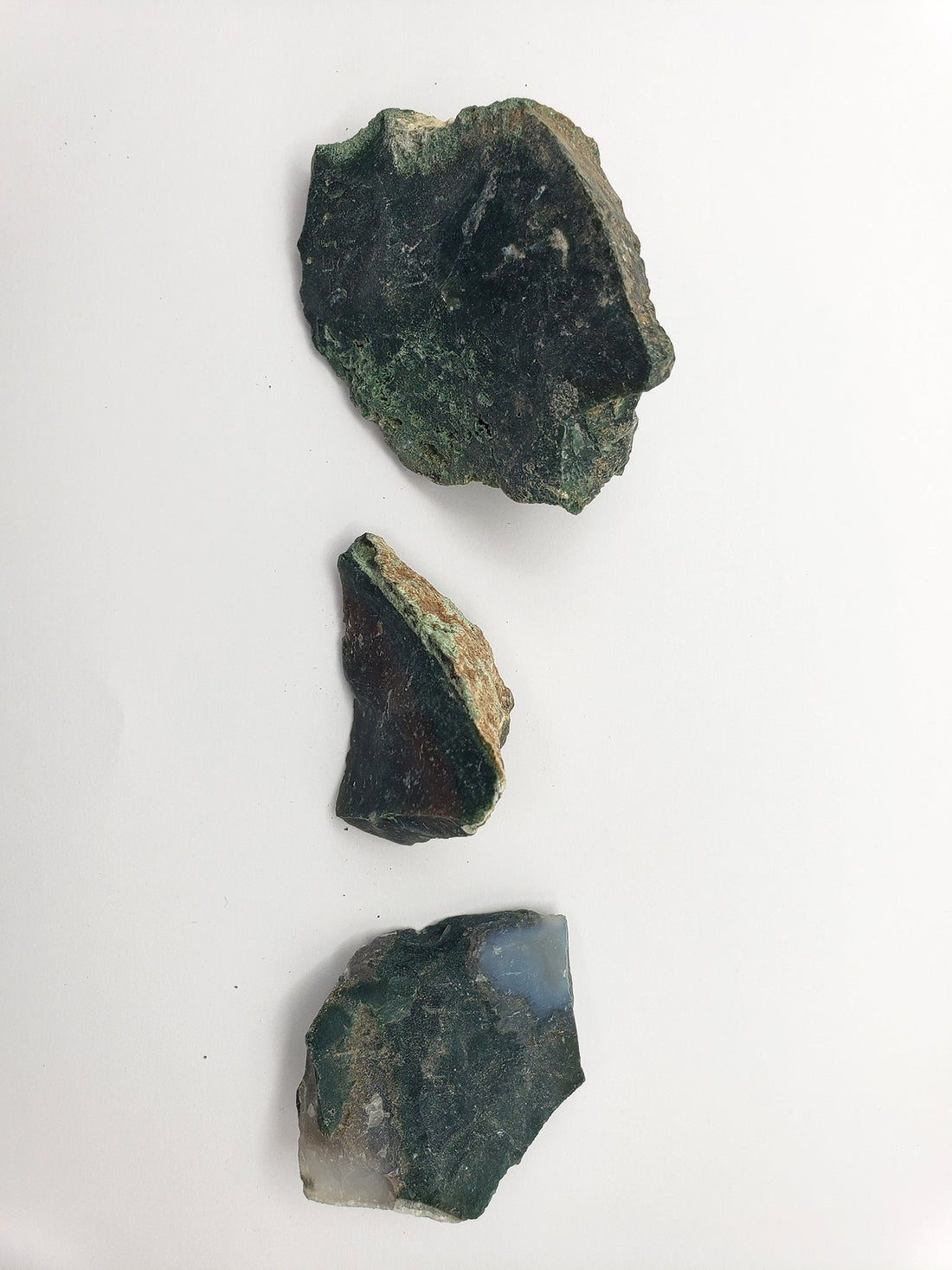 Three rough bloodstone crystal stones on white background for top-down biew