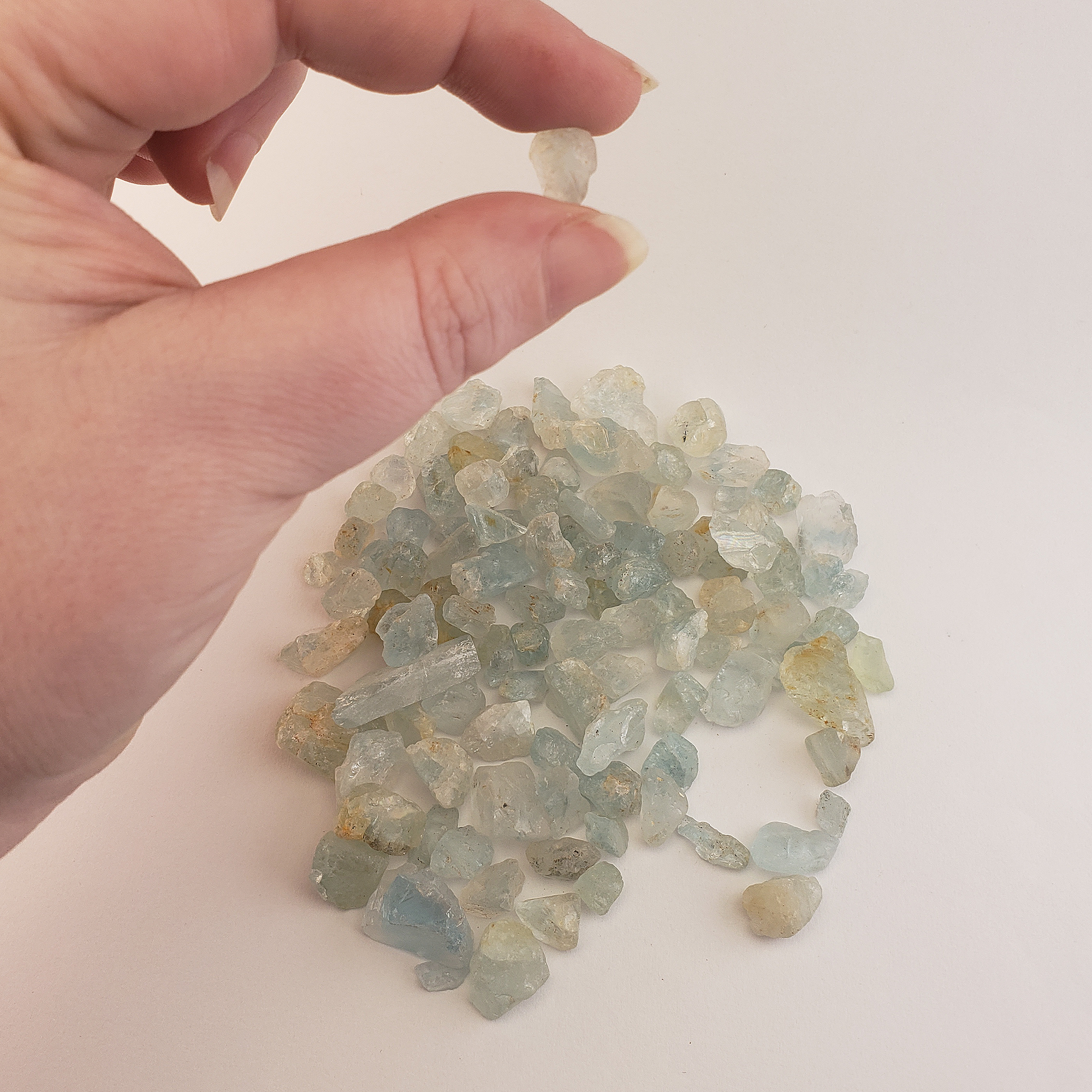 Light Blue Topaz Raw Crystals Rough Gemstones by the Half Ounce - Between Fingers