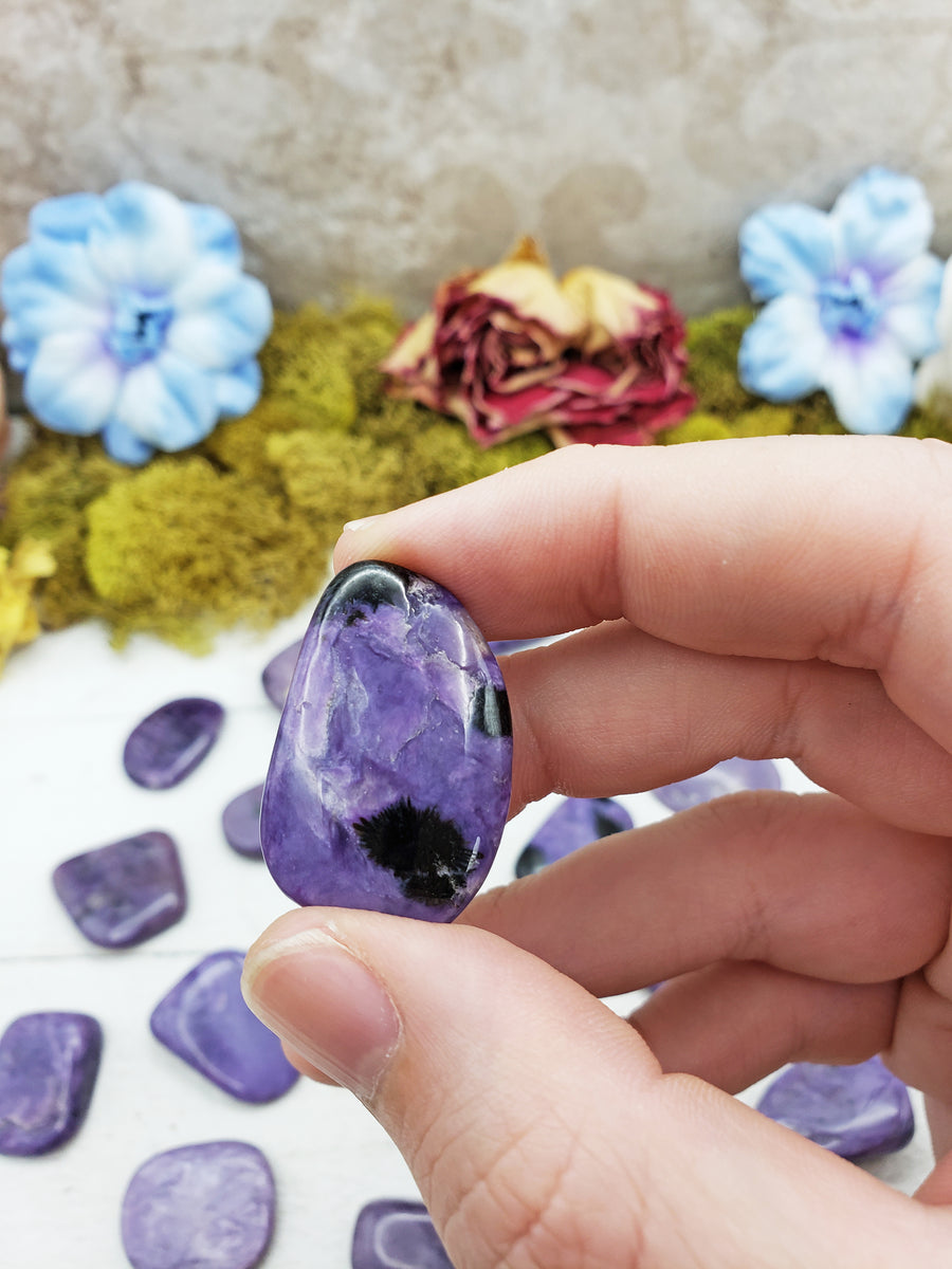 Charoite stone between fingers