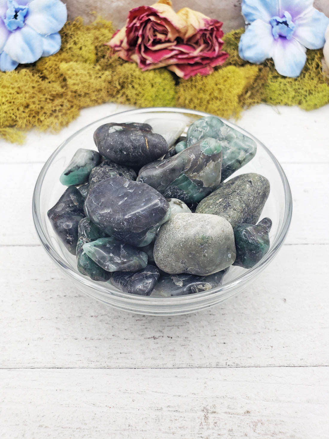 emerald in matrix stones in glass bowl