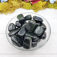 green goldstone crystals in glass bowl