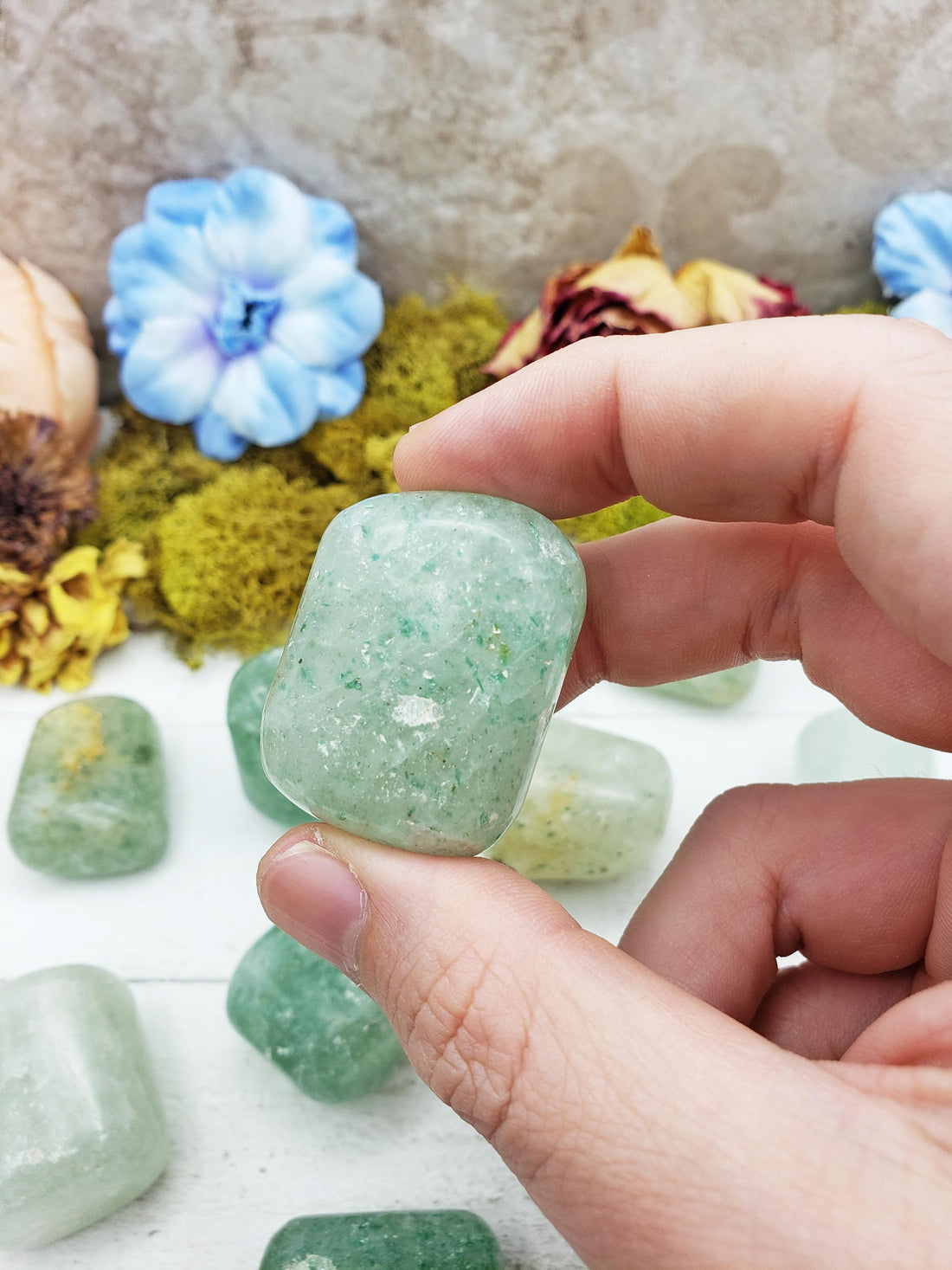 hand pinching green included quartz crystal