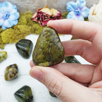 green opal stone between fingers