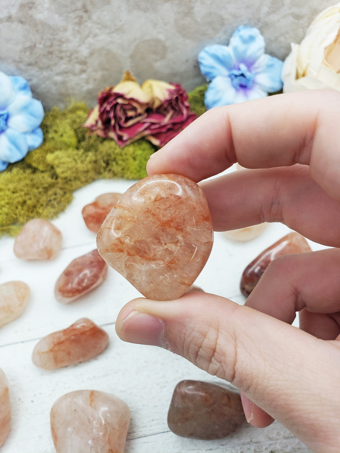light strawberry quartz stone between fingers