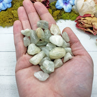 tumbled aquamarine stone in hand