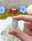 tumbled aquamarine stone pinched in hand