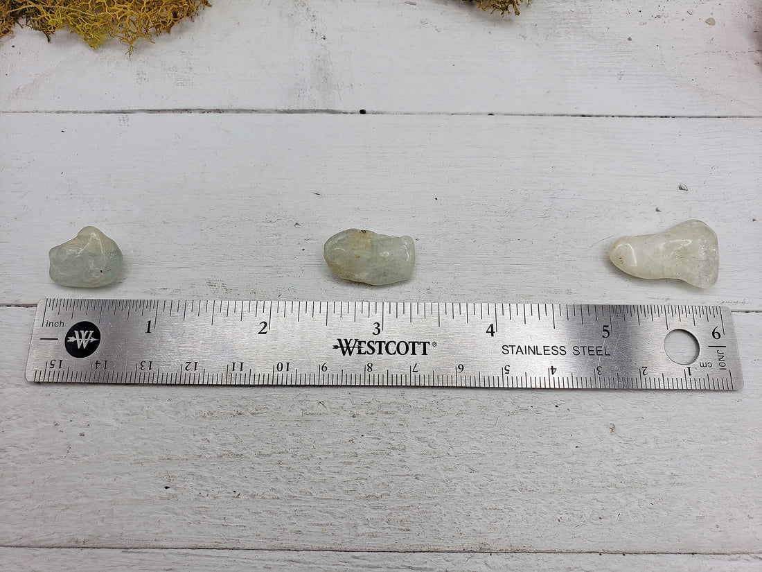 ruler comparing size of 3 tumbled aquamarine stones