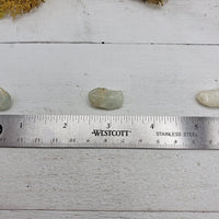 ruler comparing size of 3 tumbled aquamarine stones