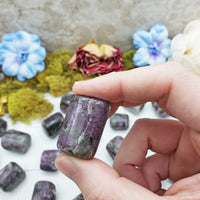 rhodolite garnet in quartz crystal between fingers