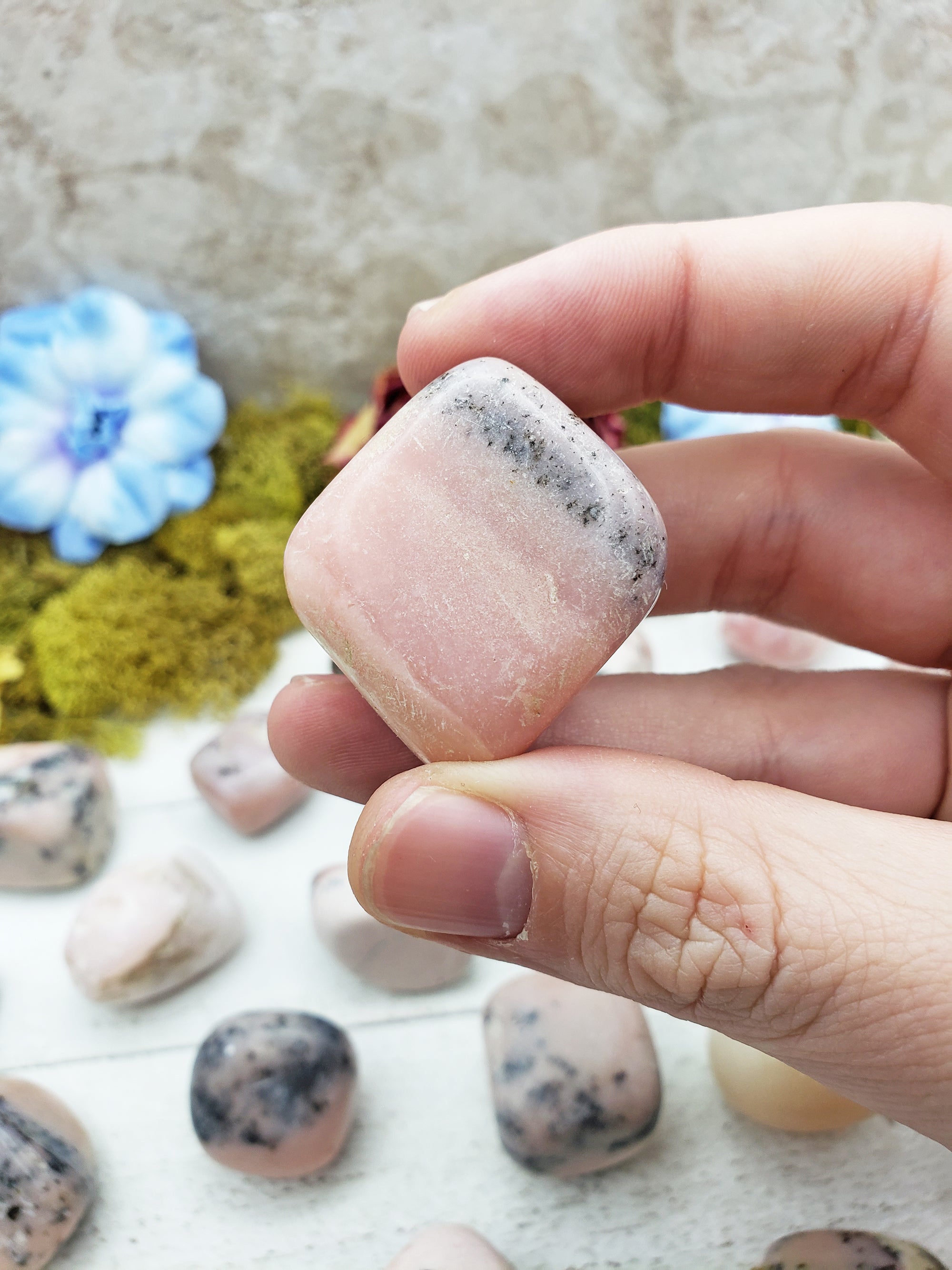 Pink Opal stone between fingers