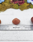 red aventurine crystals on ruler