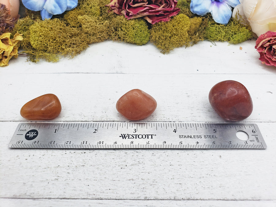 red aventurine crystals on ruler