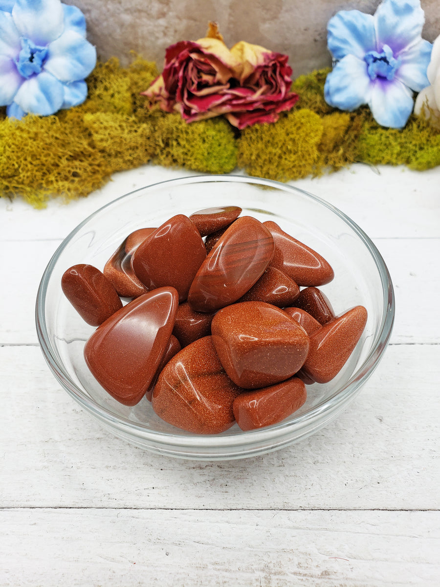 red goldstone crystals in glass bowl