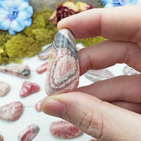 rhodocrosite stone between fingers