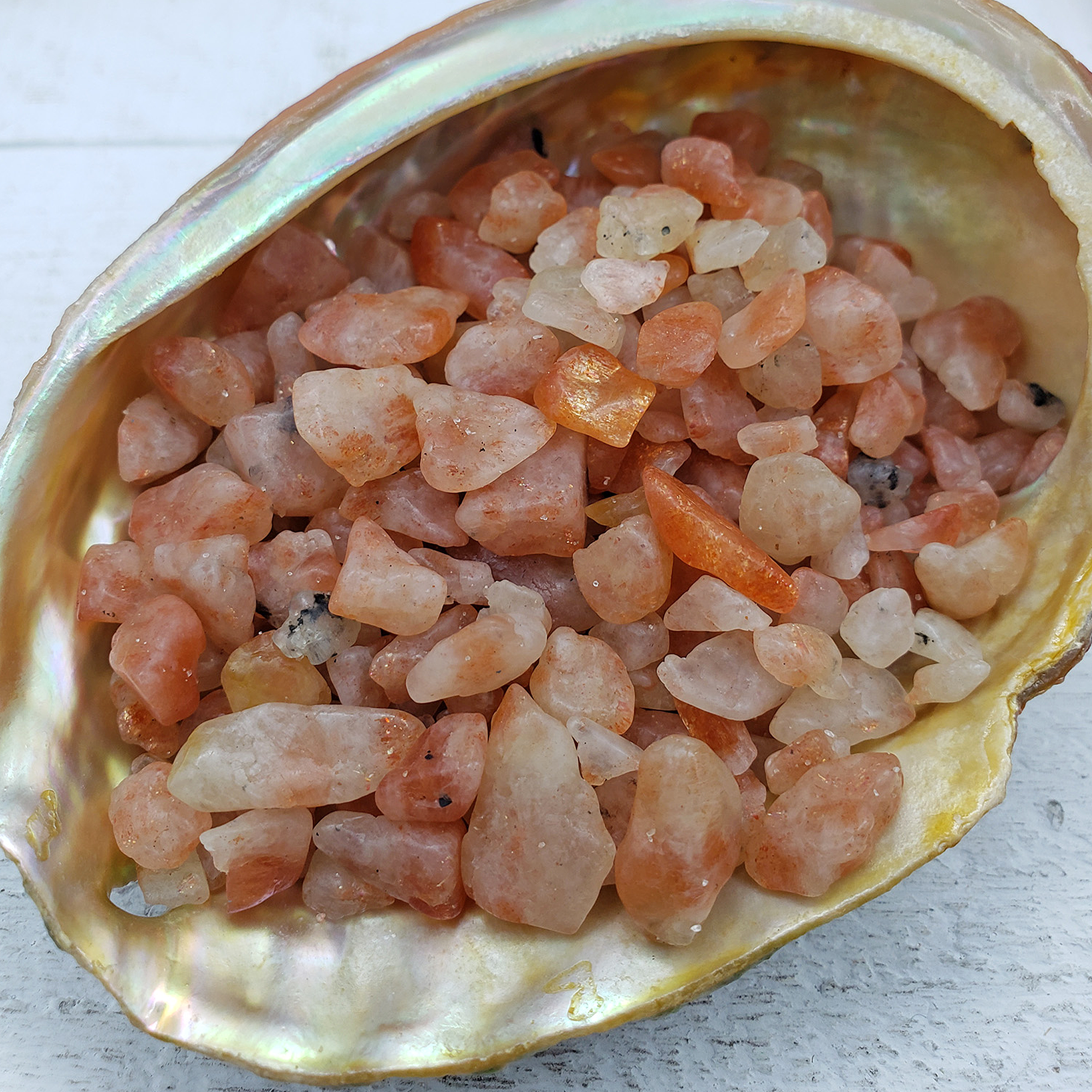 Sunstone Crystal Natural Gemstone Chips By the Ounce - Close Up of Crystal Chips in Abalone Shell