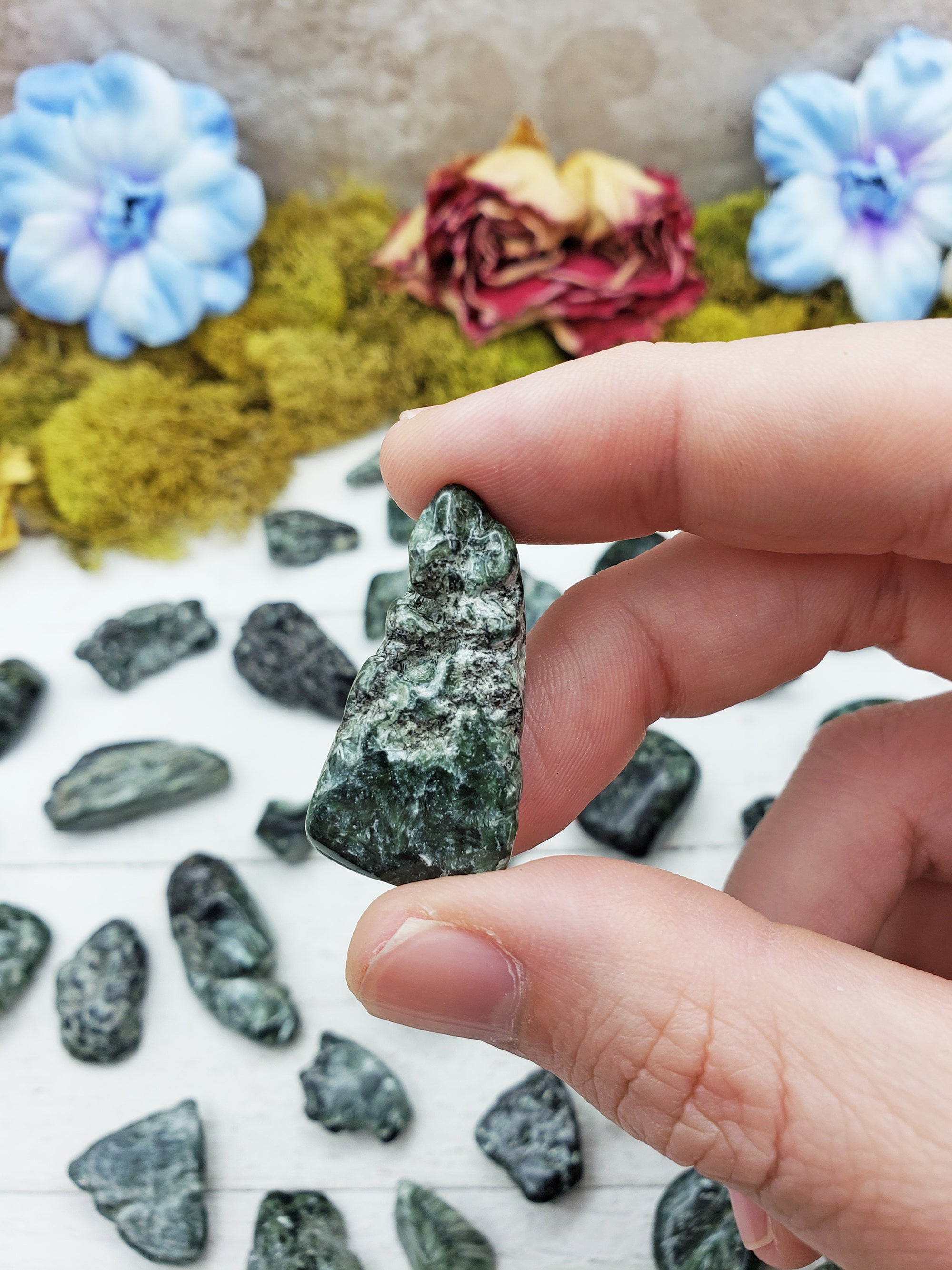 tumbled seraphinite stone between fingers