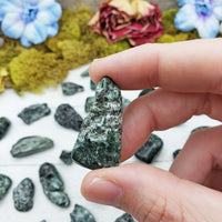 tumbled seraphinite stone between fingers