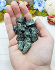 tumbled seraphinite stones in hand