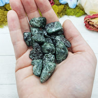 tumbled seraphinite stones in hand