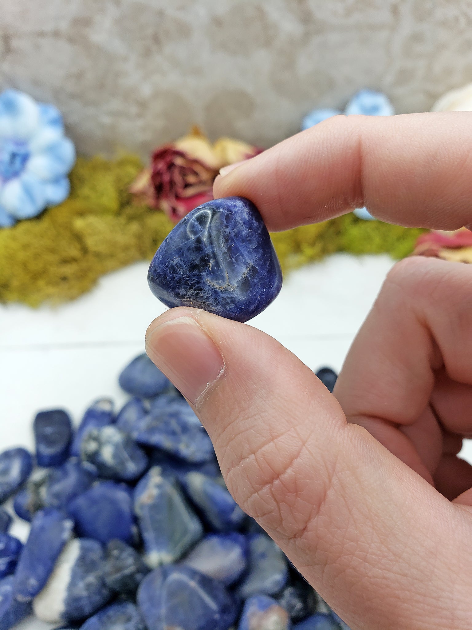 tumbled sodalite crystal pinched between fingers