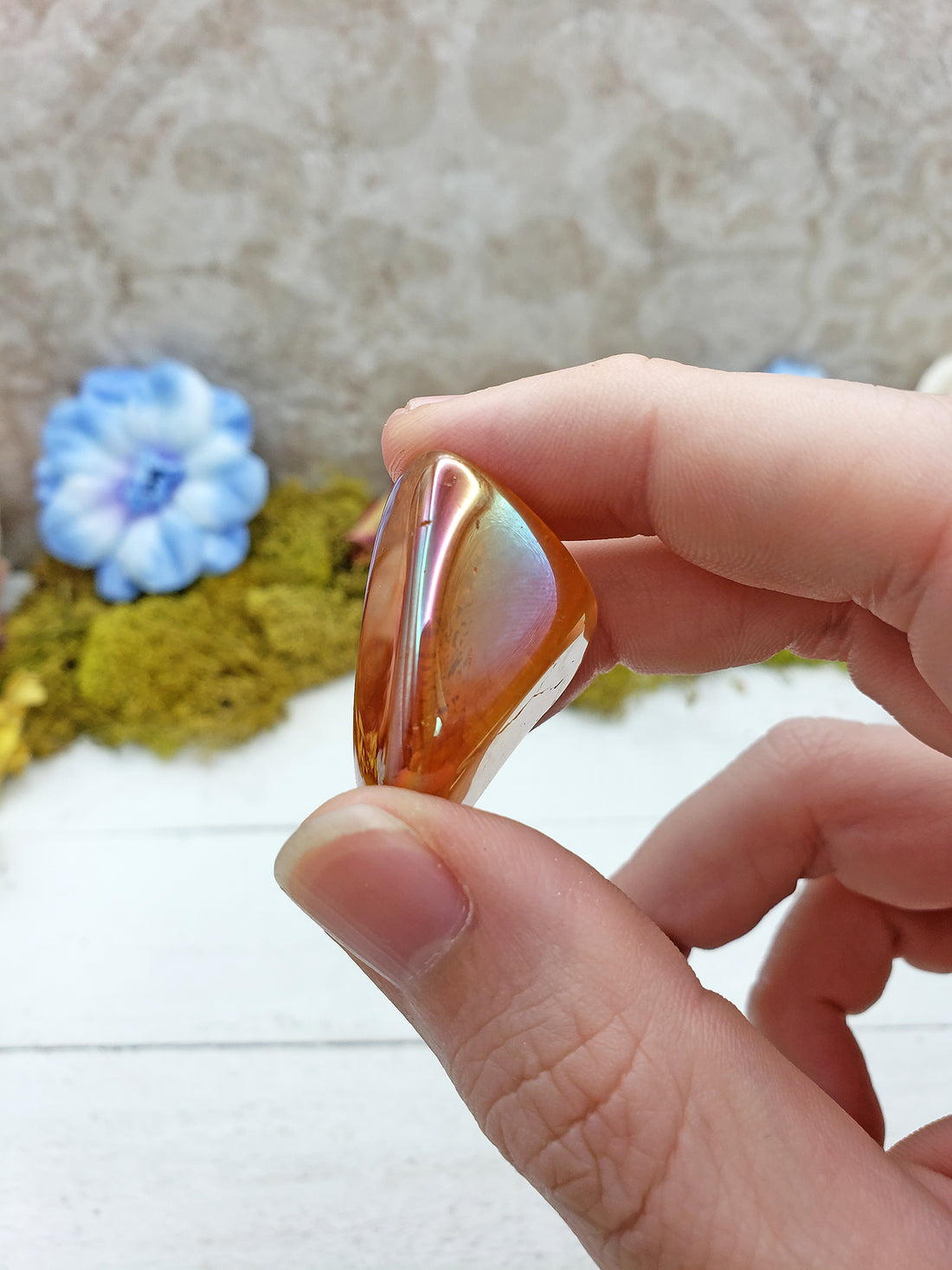 hand pinching tangerine aura quartz