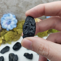 tektite stone between fingers