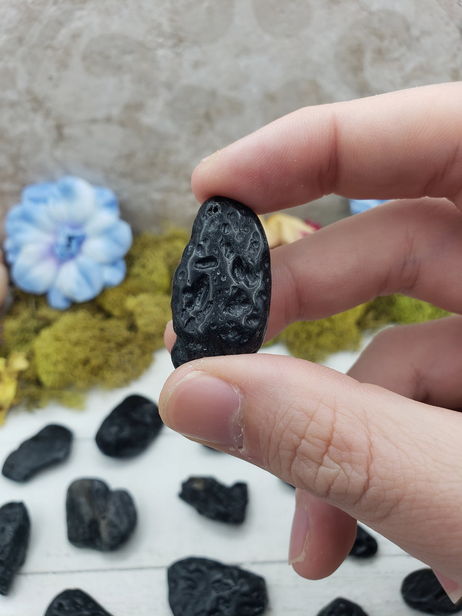 tektite stone between fingers