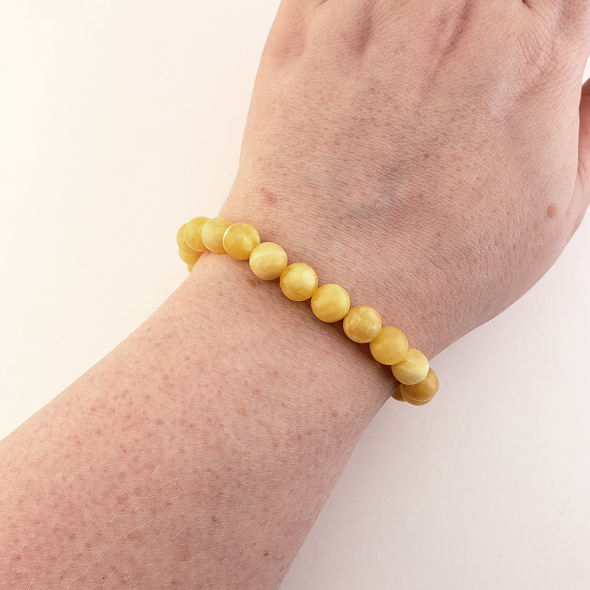 Yellow Calcite Gemstone 8mm Bead Bracelet - On Wrist Over White Background