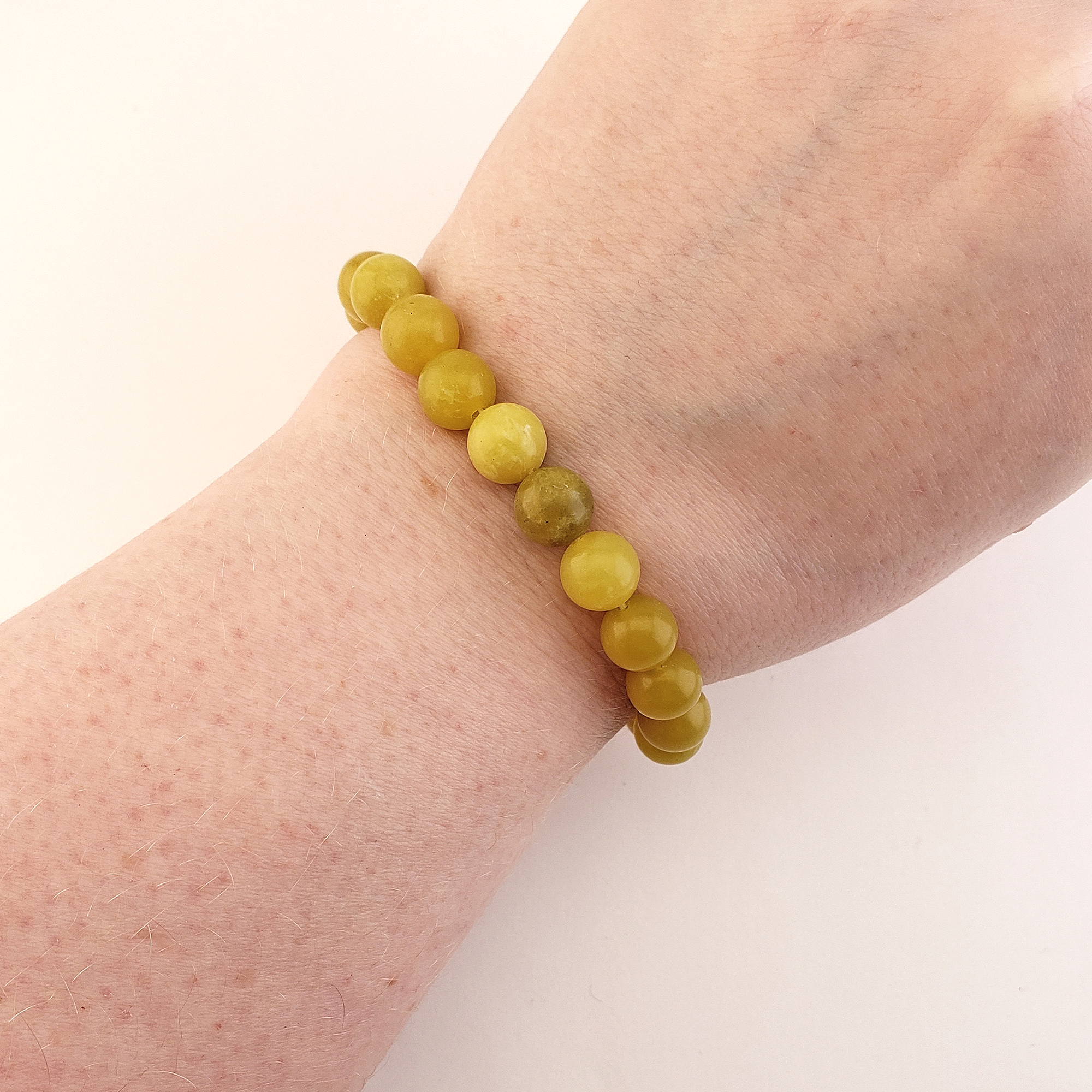 Yellow Serpentine Natural Crystal 7-8mm Bead Bracelet - Serpentine Crystal Bracelet on Wrist Above White Background