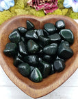 green goldstone crystals in heart-shaped bowl