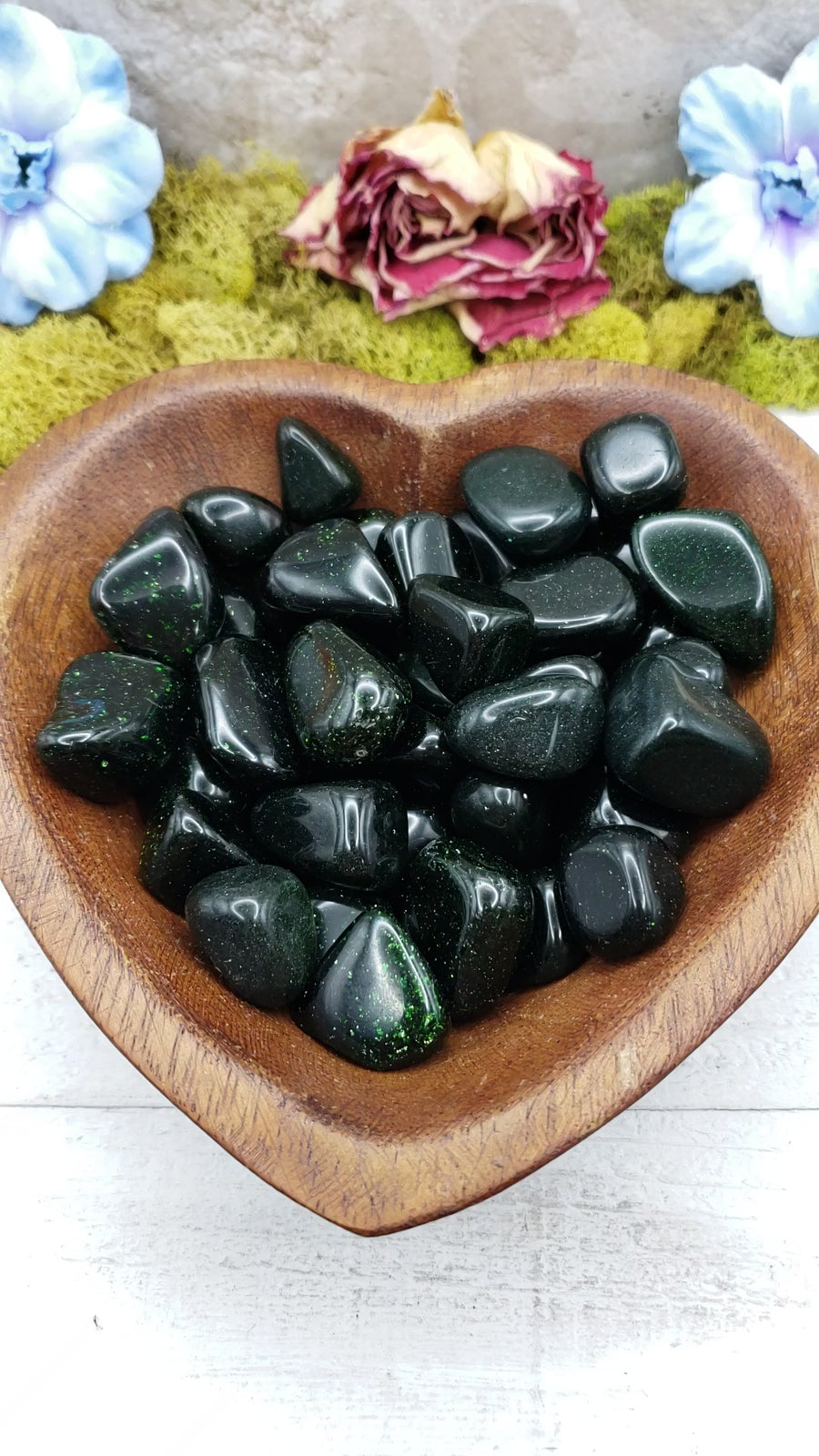 green goldstone crystals in heart-shaped bowl