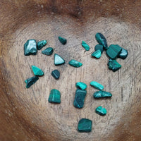 malachite crystal chips being poured into bowl