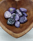 video of charoite stone pieces in wooden bowl