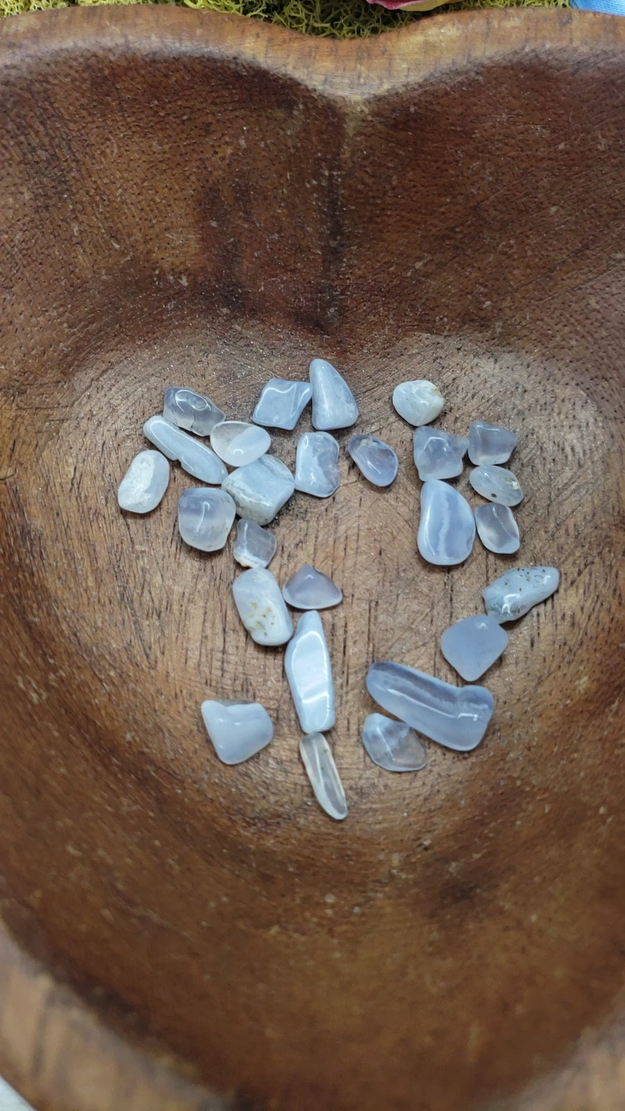 blue agate crystal chips being poured into heart bowl