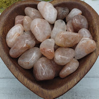video of light strawberry quartz stones in heart-shaped bowl