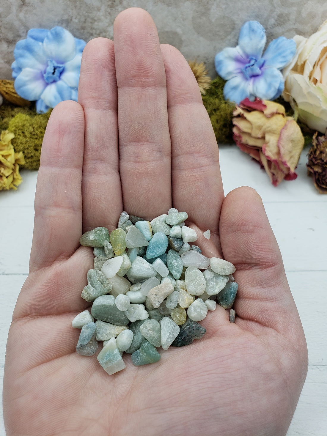 hand holding one ounce of amazonite stone chips