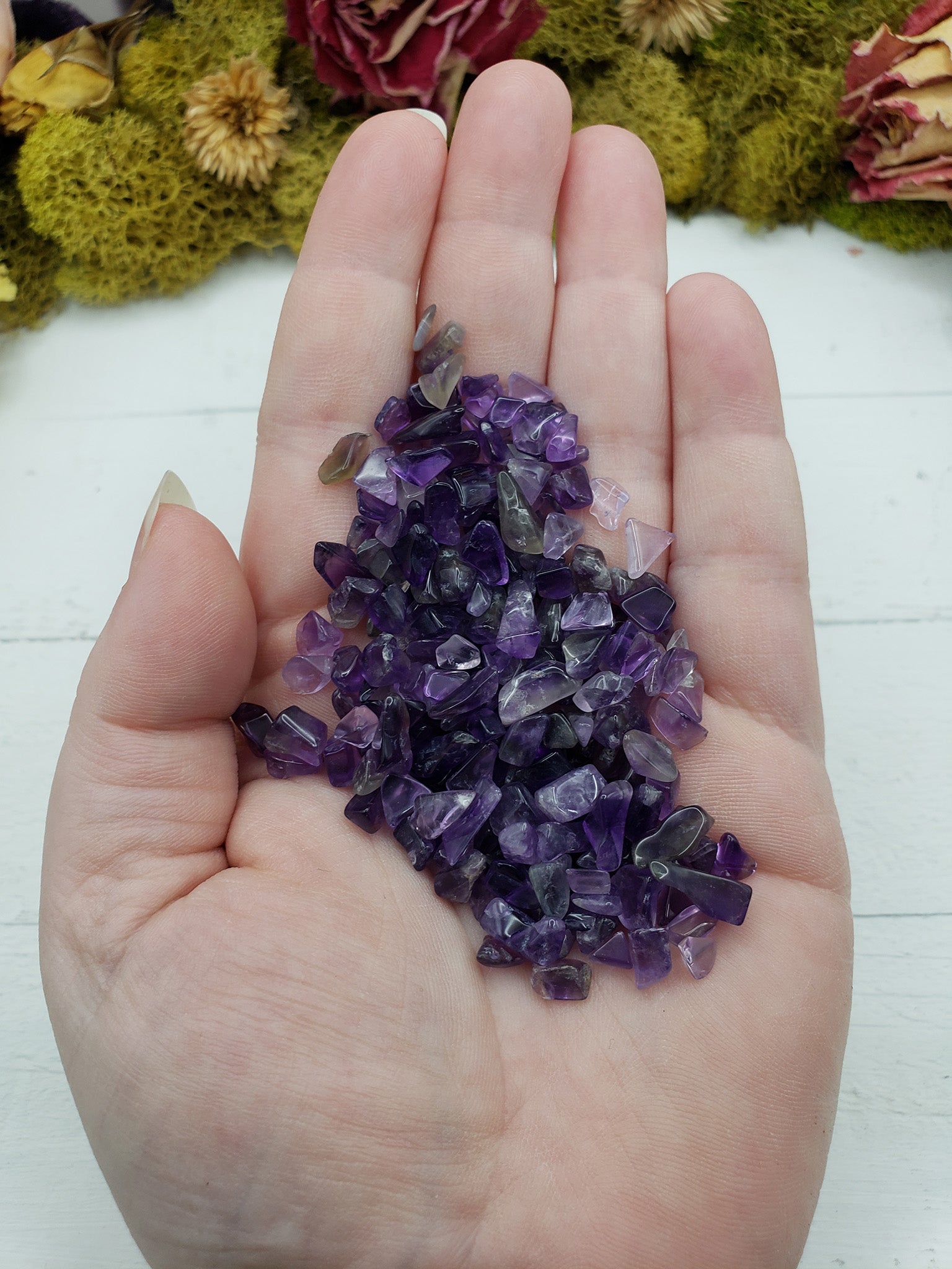 hand holding one ounce of amethyst crystal chips