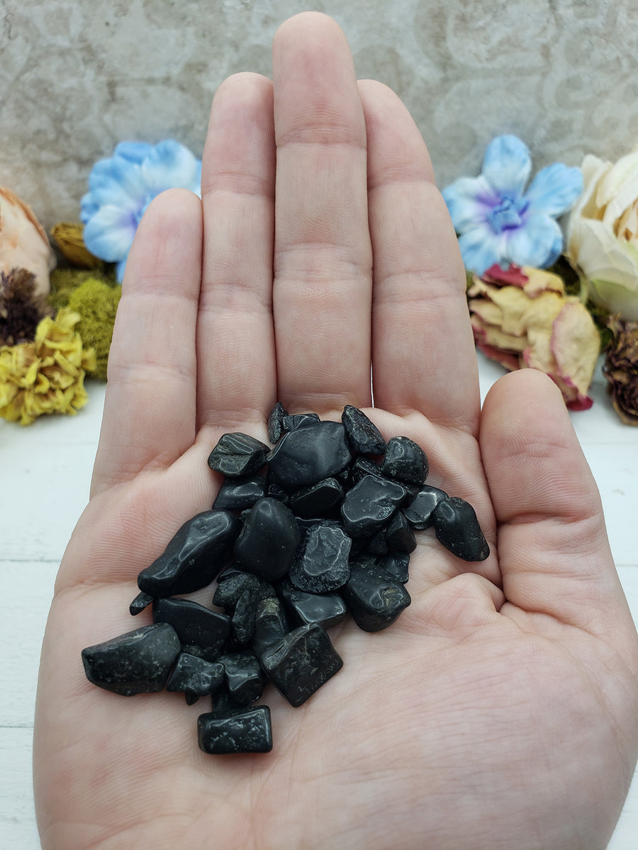 hand holding 1 ounce of black tourmaline crystal chips