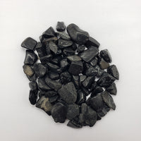one ounce of black tourmaline crystal chips on white background