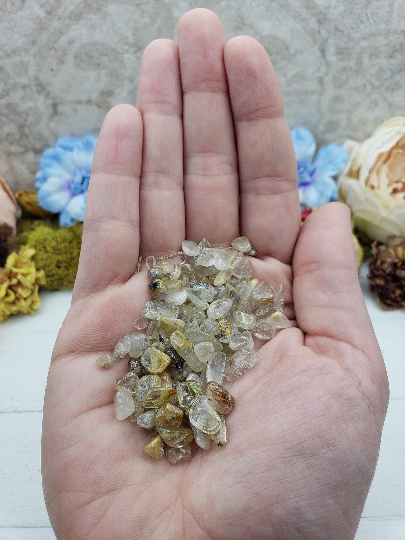 One ounce gold rutile quartz chips in hand