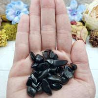 Hand holding one ounce of Obsidian stone chips