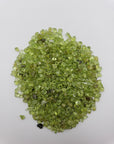 one ounce of peridot stone chips on white background