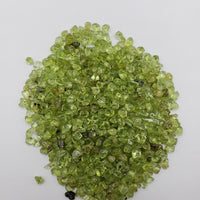 one ounce of peridot stone chips on white background