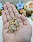 hand holding one ounce of cherry blossom agate chips