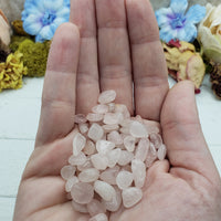hand holding one ounce of rose quartz stone chips