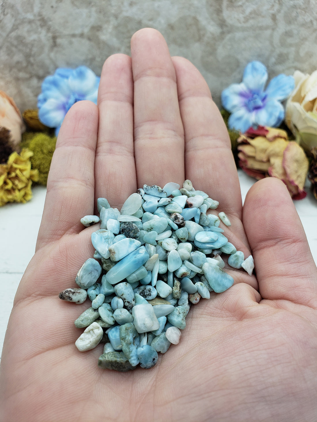 Hand holding one ounce of larimar chips