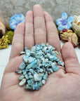 Hand holding one ounce of larimar chips