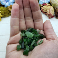 Hand holding one ounce of nephrite jade chips