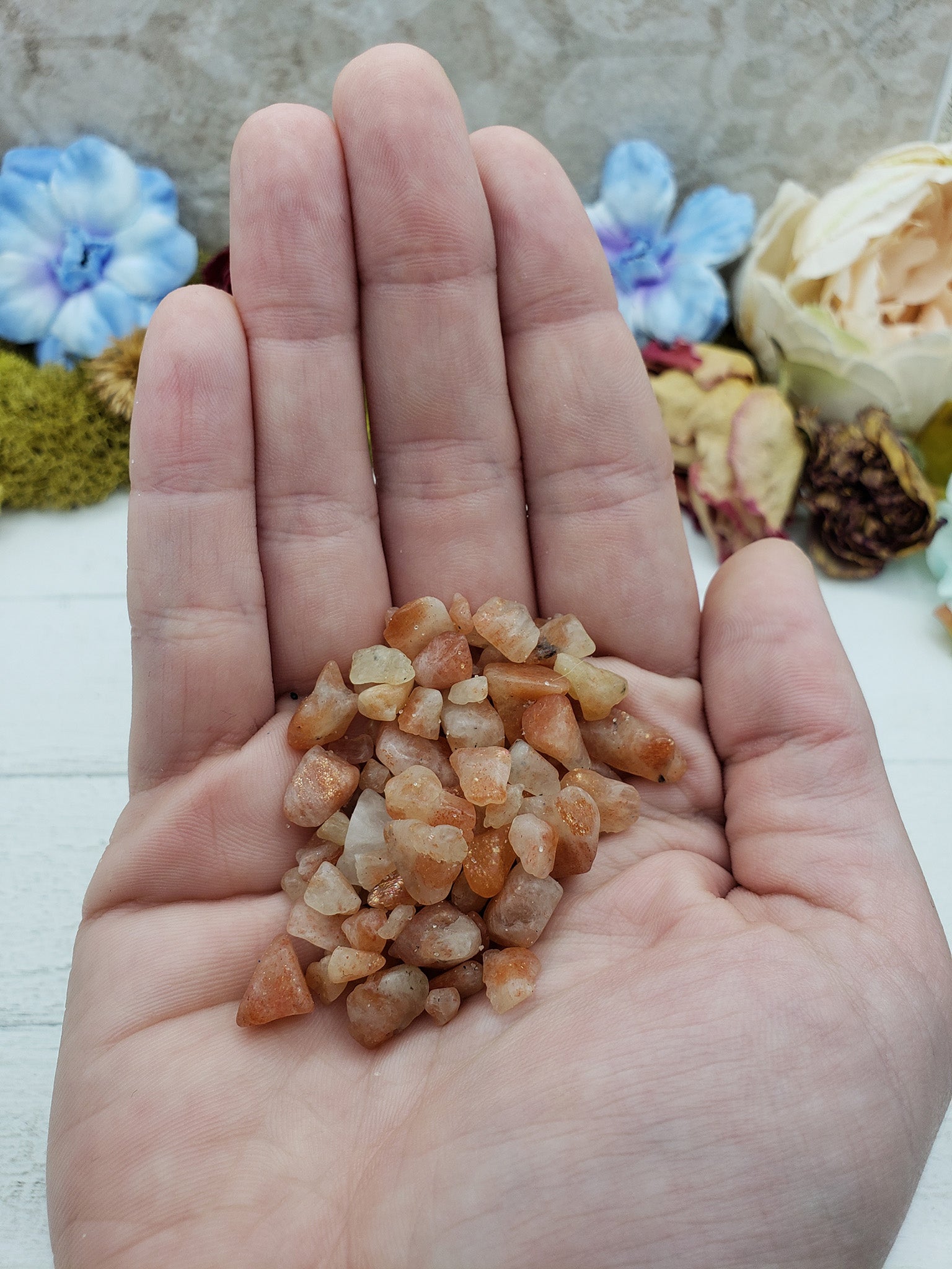 hand holding one ounce of sunstone chips