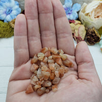 hand holding one ounce of sunstone chips